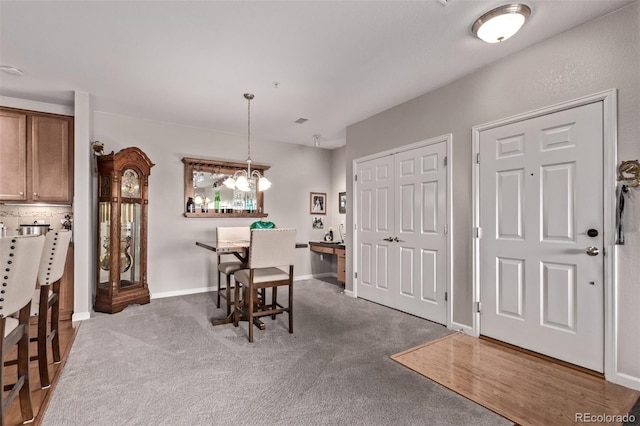 carpeted dining room with baseboards, a notable chandelier, and visible vents