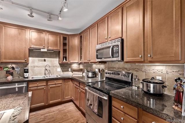 kitchen featuring brown cabinetry, appliances with stainless steel finishes, and a sink