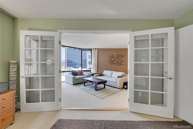 living room featuring a textured ceiling, carpet floors, and french doors