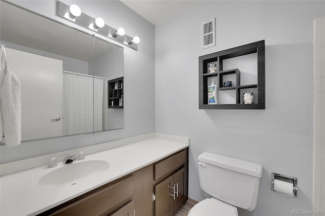 bathroom featuring walk in shower, vanity, and toilet