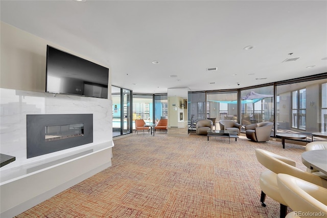 carpeted living room featuring a wall of windows