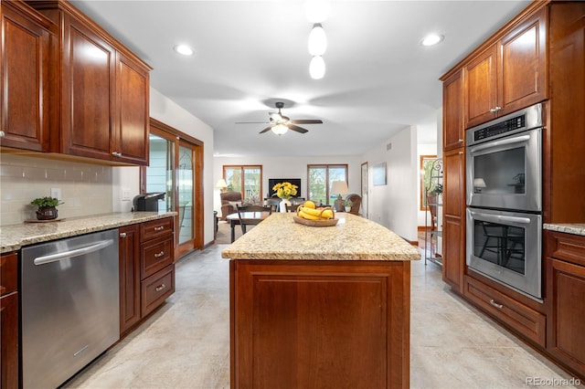 kitchen featuring decorative backsplash, a ceiling fan, a center island, open floor plan, and stainless steel appliances