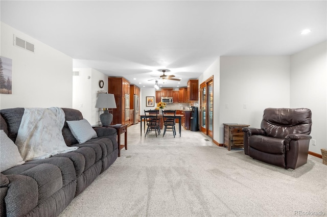 living room featuring visible vents, recessed lighting, and light colored carpet