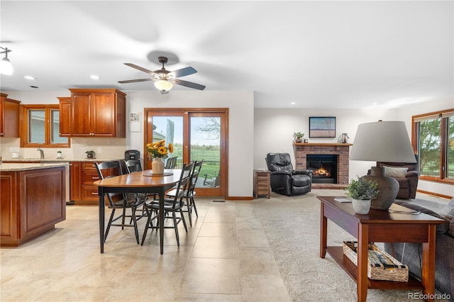 dining space featuring recessed lighting, a ceiling fan, baseboards, and a fireplace