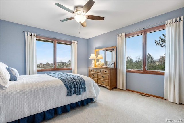 carpeted bedroom with visible vents, baseboards, and ceiling fan
