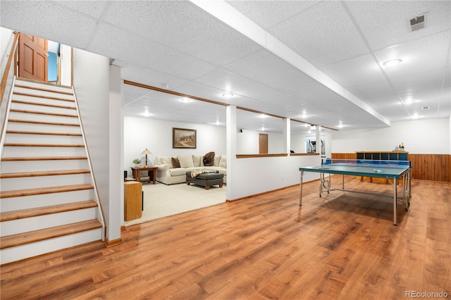 rec room with a paneled ceiling, wood finished floors, and visible vents