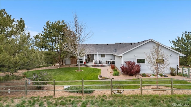 rear view of property with a lawn, a shingled roof, fence, and a patio