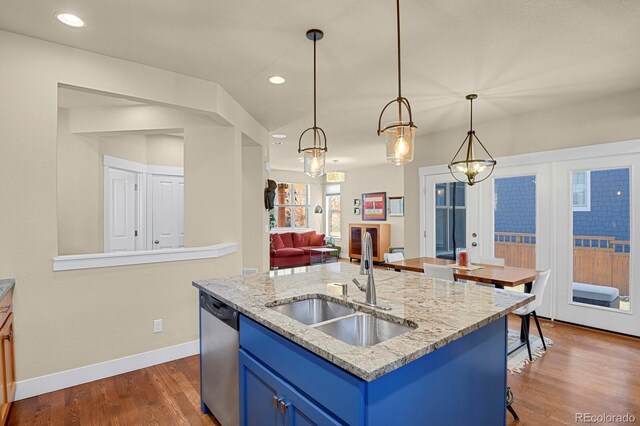 kitchen with dark wood-type flooring, a sink, baseboards, blue cabinetry, and dishwasher