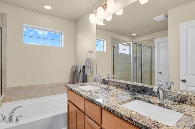 bathroom with a garden tub, a stall shower, a sink, and visible vents