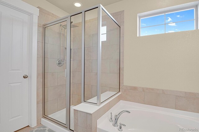 bathroom featuring a stall shower and a garden tub