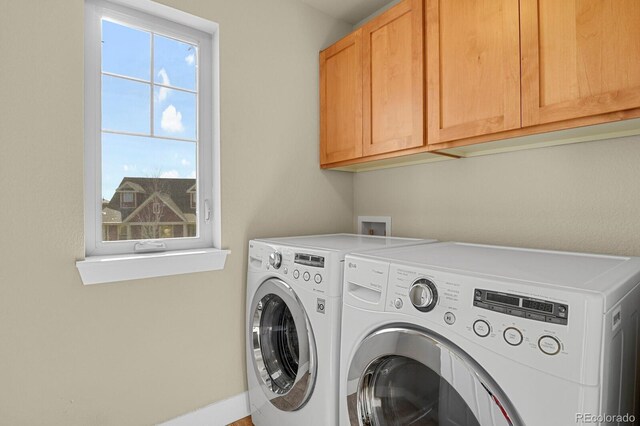 laundry area featuring washing machine and clothes dryer and cabinet space