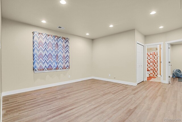 spare room featuring light wood finished floors, baseboards, visible vents, and recessed lighting