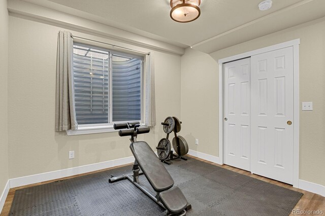 exercise area with wood finished floors and baseboards