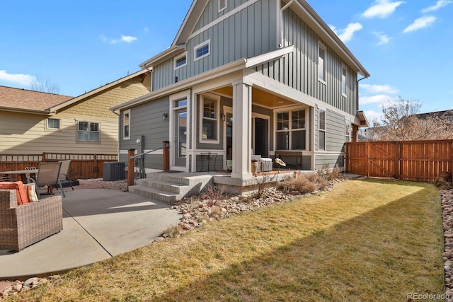 back of house featuring central AC unit, a patio, fence, a yard, and board and batten siding