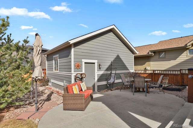 back of property with outdoor dining space, a patio area, and fence