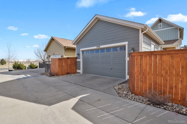 view of side of home with driveway and fence