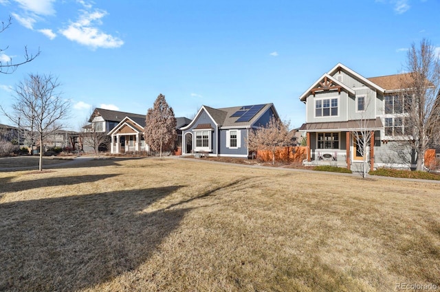 view of front of home with covered porch, metal roof, a front lawn, and a standing seam roof