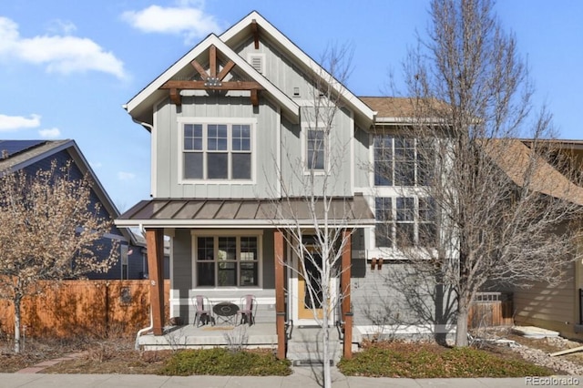 view of front of house featuring covered porch, board and batten siding, a standing seam roof, metal roof, and fence