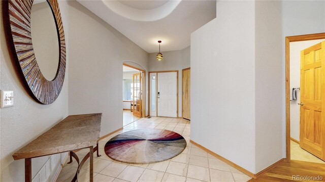 9559 Brook Hill Ln, Lone Tree, CO 80124 - foyer featuring arched walkways, light tile patterned floors, and baseboards