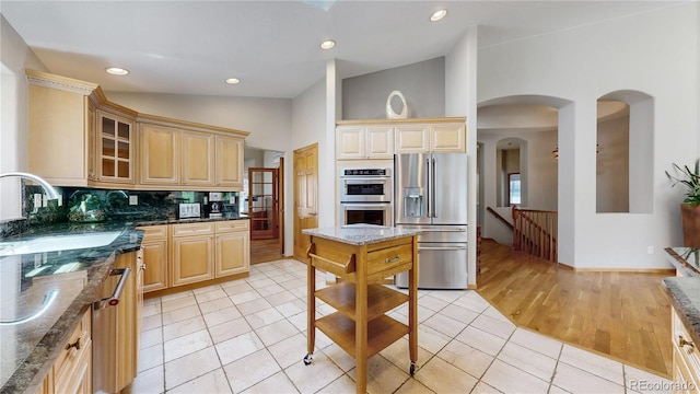 9559 Brook Hill Ln, Lone Tree, CO 80124 - kitchen featuring stainless steel appliances, a sink, lofted ceiling, backsplash, and glass insert cabinets
