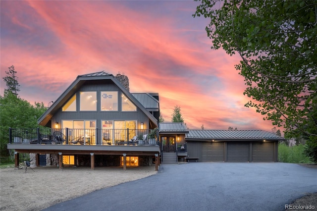 189 Pine Cone Ln, Winter Park, CO 80482 - view of front facade featuring a standing seam roof, asphalt driveway, a metal roof, a chimney, and a wooden deck