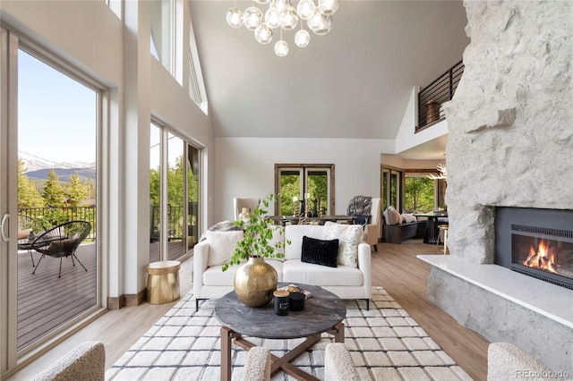 189 Pine Cone Ln, Winter Park, CO 80482 - living room featuring a high ceiling, a high end fireplace, light wood-type flooring, a chandelier, and a mountain view