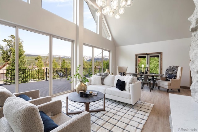 189 Pine Cone Ln, Winter Park, CO 80482 - living area featuring high vaulted ceiling, healthy amount of natural light, a chandelier, light wood-style flooring, and a mountain view