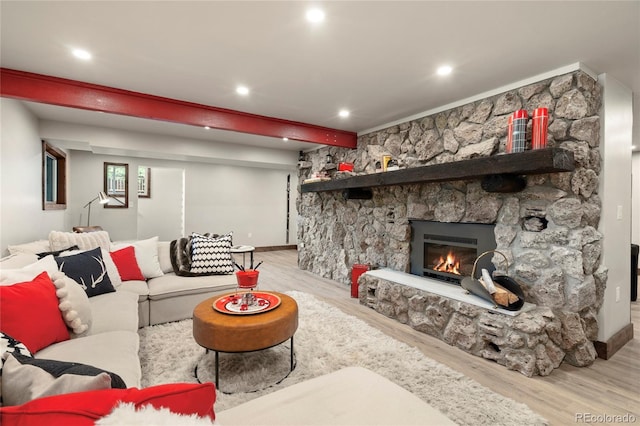 189 Pine Cone Ln, Winter Park, CO 80482 - living room featuring wood finished floors, a stone fireplace, recessed lighting, and beamed ceiling