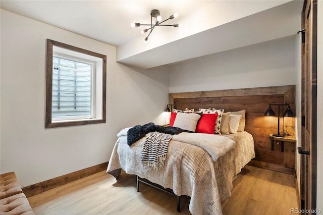 189 Pine Cone Ln, Winter Park, CO 80482 - bedroom featuring wood finished floors and a chandelier