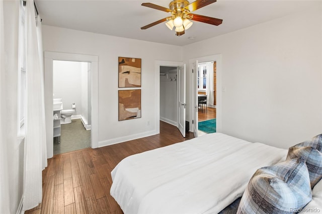 bedroom with connected bathroom, dark hardwood / wood-style floors, and ceiling fan