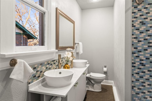 bathroom featuring tasteful backsplash, vanity, and toilet