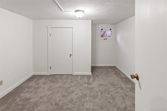 empty room featuring light carpet and a textured ceiling