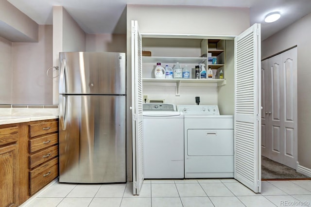 washroom featuring independent washer and dryer and light tile patterned floors