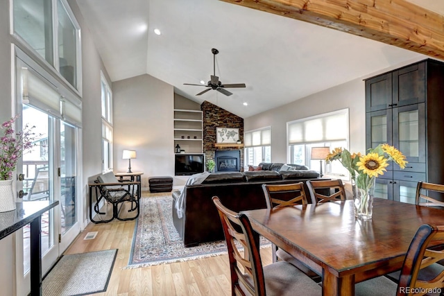 7877 S University Way, Centennial, CO 80122 - dining space with light wood finished floors, a ceiling fan, a stone fireplace, built in features, and high vaulted ceiling