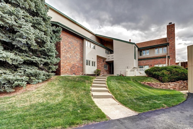 7877 S University Way, Centennial, CO 80122 - view of front of home with a front yard and brick siding