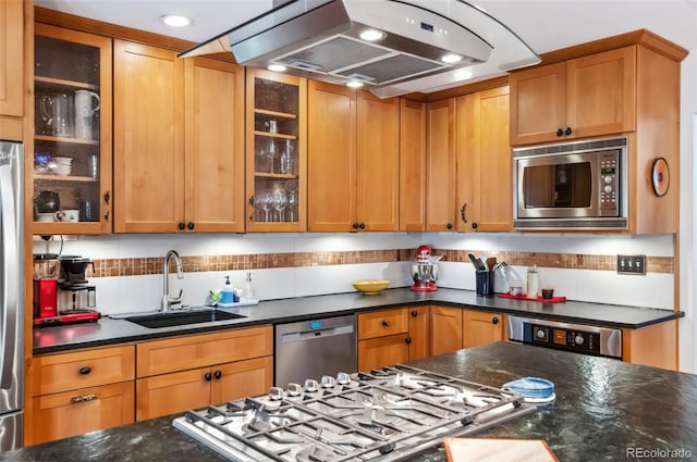 kitchen featuring backsplash, dark stone counters, island range hood, sink, and stainless steel appliances