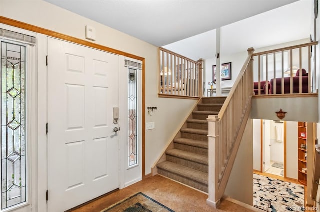 foyer entrance featuring light carpet