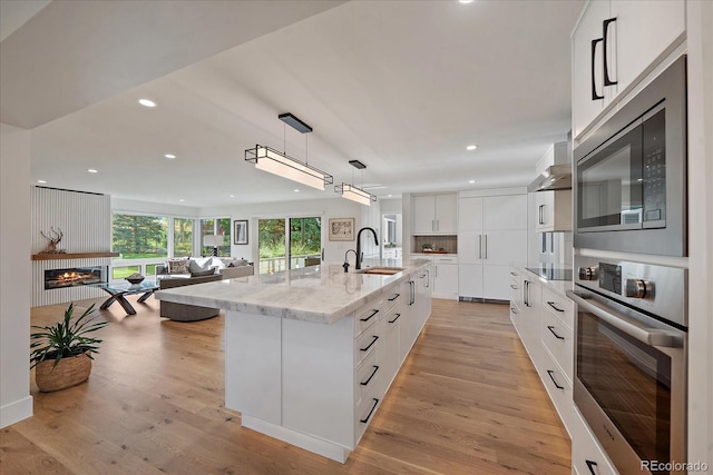 kitchen with white cabinets, a large island, and appliances with stainless steel finishes