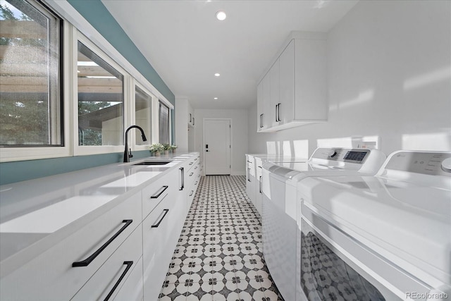 washroom with cabinets, sink, and washing machine and dryer