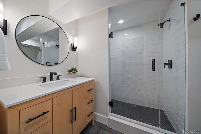 bathroom with a shower with shower door and vanity