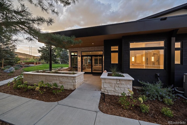 exterior entry at dusk with a patio