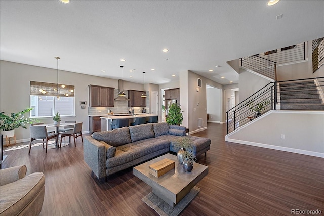 living room featuring sink and dark hardwood / wood-style flooring