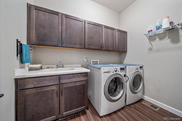 laundry room with washer and dryer, dark wood-type flooring, cabinets, and sink