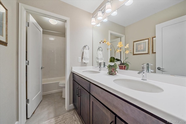 full bathroom with tile patterned flooring, tiled shower / bath combo, vanity, and toilet