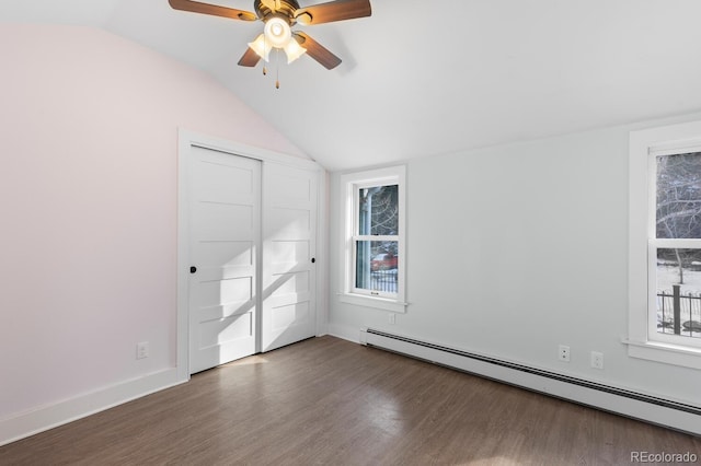 interior space with dark hardwood / wood-style flooring, a baseboard heating unit, ceiling fan, and vaulted ceiling