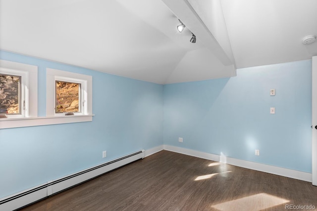 spare room with dark hardwood / wood-style flooring, a baseboard radiator, rail lighting, and vaulted ceiling