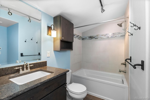 full bathroom with washtub / shower combination, toilet, track lighting, vanity, and lofted ceiling