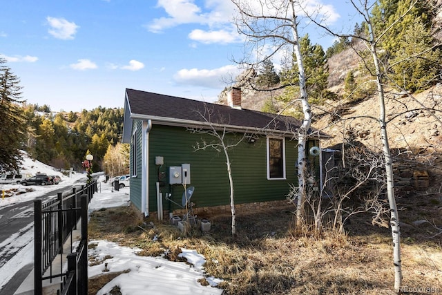 401 Chase St, Black Hawk, CO 80422 - view of snow covered exterior featuring a chimney and roof with shingles