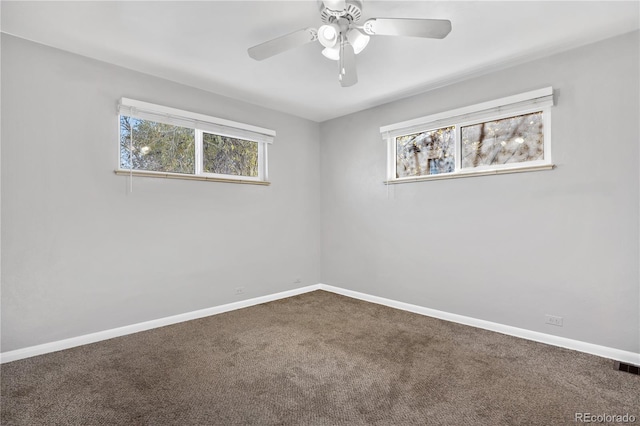 carpeted spare room featuring ceiling fan