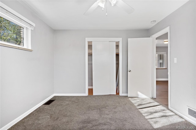 unfurnished bedroom featuring carpet flooring, a closet, and ceiling fan